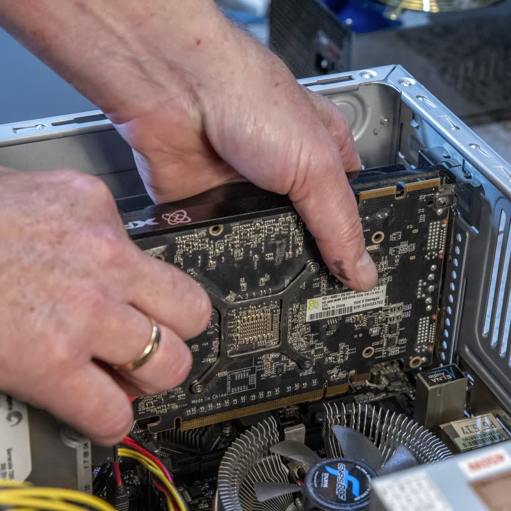 Bild zum Abschnitt Hardware, Verkauf und Service zeigt Herrn Eickmann bei der Reperatur eines Computers